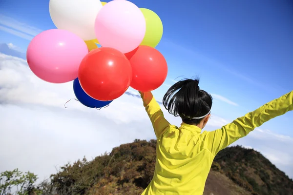 Jublende kvinne med fargerike ballonger – stockfoto