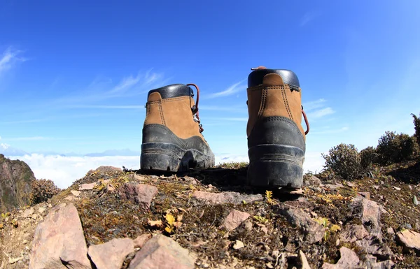 Botas de caminhada no pico da montanha — Fotografia de Stock