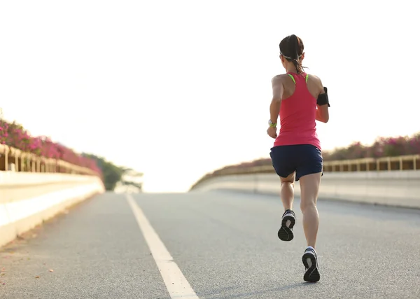 Kvinnan löpare körs på väg — Stockfoto