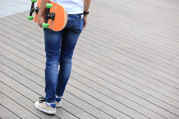 ボードを持つ女性スケートボーダー — ストック写真