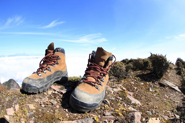 Botas de caminhada no pico da montanha — Fotografia de Stock