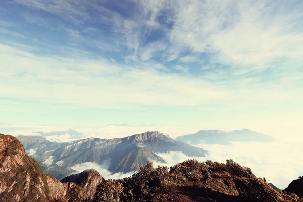 Nubes ondulantes y montaña — Foto de Stock