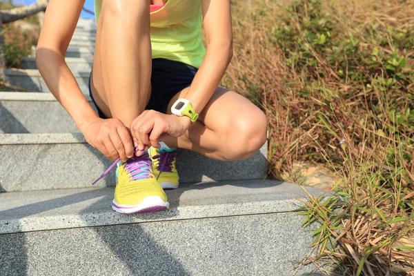 Mujer corredora atando cordones — Foto de Stock