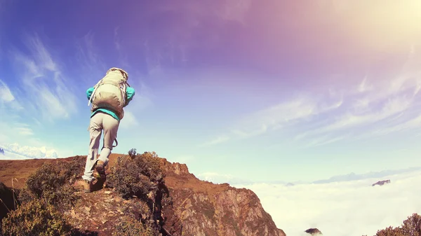 Vrouw backpacker klimmen naar berg — Stockfoto