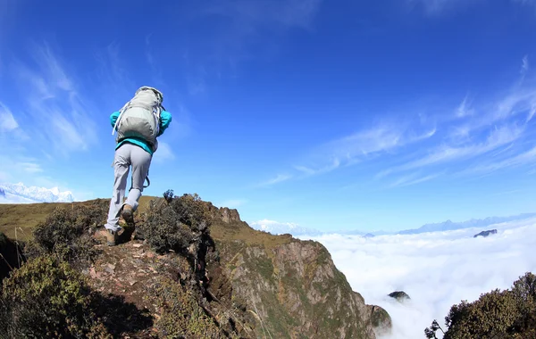 Vrouw backpacker klimmen naar berg — Stockfoto