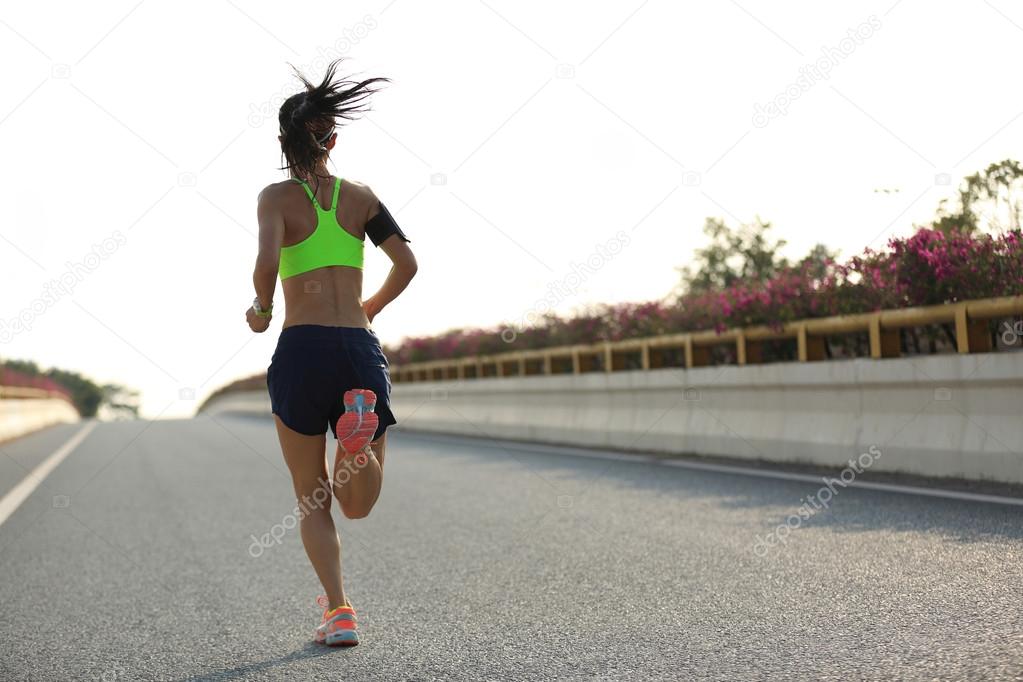 woman runner running on road