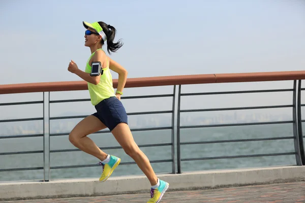 Mujer corredor corriendo a la orilla del mar —  Fotos de Stock