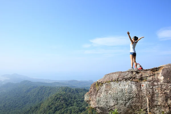 Torcendo jovem mulher no pico da montanha — Fotografia de Stock