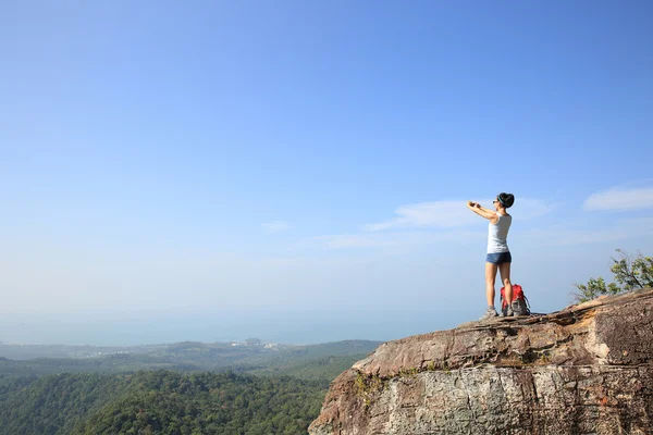 Mujer joven con cámara en la montaña — Foto de Stock