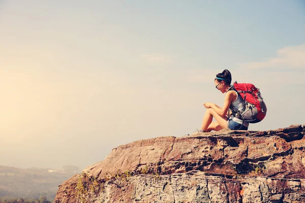 Mujer usando smartphone en pico de montaña — Foto de Stock