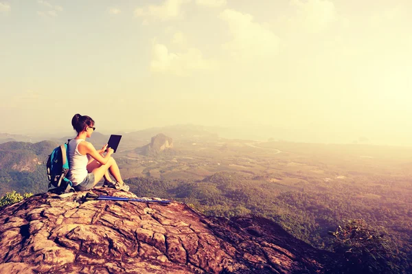 Woman using digital tablet on mountain — Stock Photo, Image