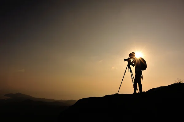 Mulher fotógrafa no pôr do sol montanha — Fotografia de Stock