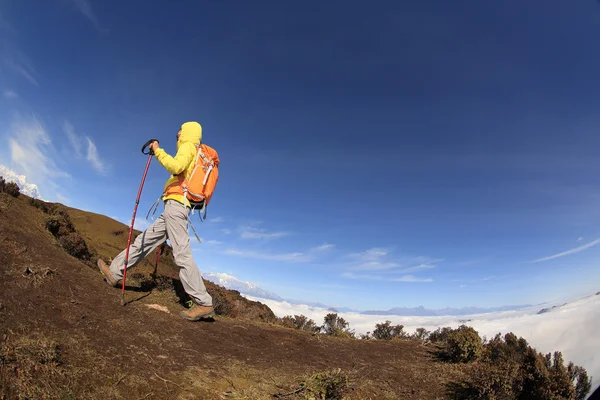 Kvinnan backpacker klättring på berg — Stockfoto