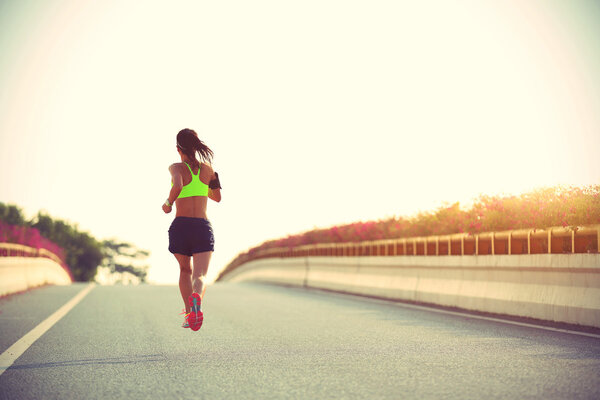 young fitness woman on city bridge