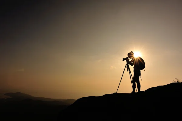 Vrouw fotograaf op de bergtop — Stockfoto