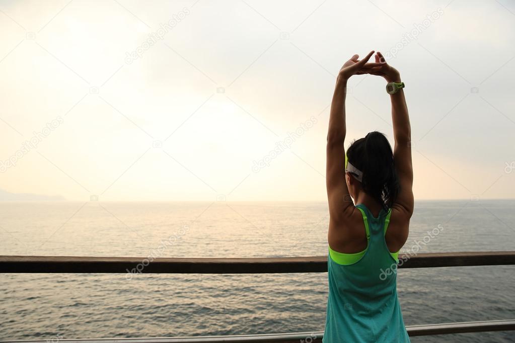 sporty woman stretching over seaside