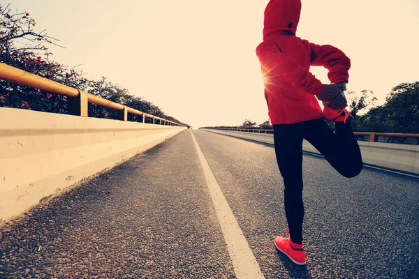 拉伸腿的女跑步运动员 — 图库照片