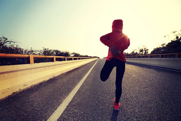 Kvinnan löpare sträcker benet — Stockfoto