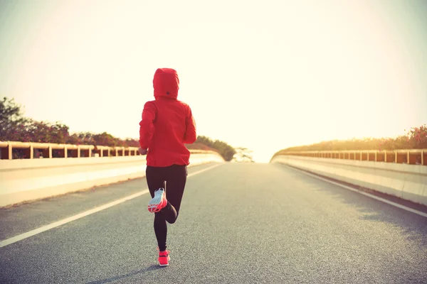 Sportiga kvinnan löpare på vägen — Stockfoto
