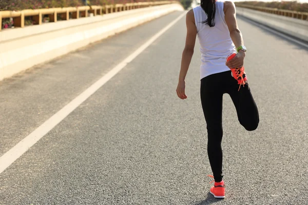 Žena běžec protahování nohou — Stock fotografie