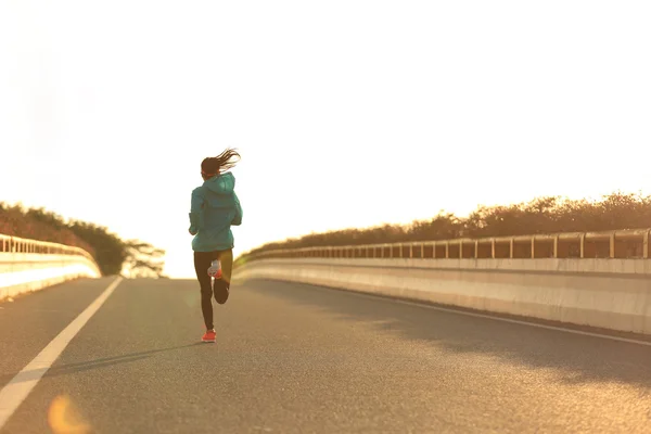 Sportieve vrouw draait op weg — Stockfoto