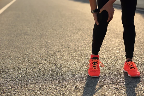 Woman runner with injured leg — Stock Photo, Image