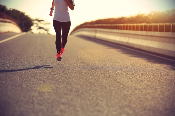 Спортивна жінка біжить по дорозі — стокове фото