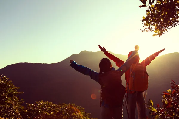 Backpackers with open arms at mountain — Stock Photo, Image