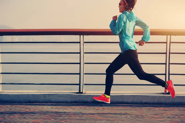 Mujer corriendo en la orilla del mar — Foto de Stock