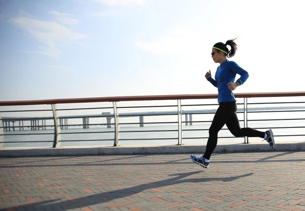 Mujer corriendo en la orilla del mar — Foto de Stock