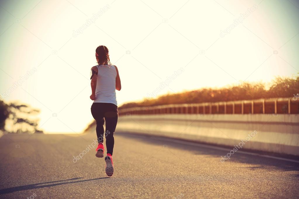 sporty woman running on road