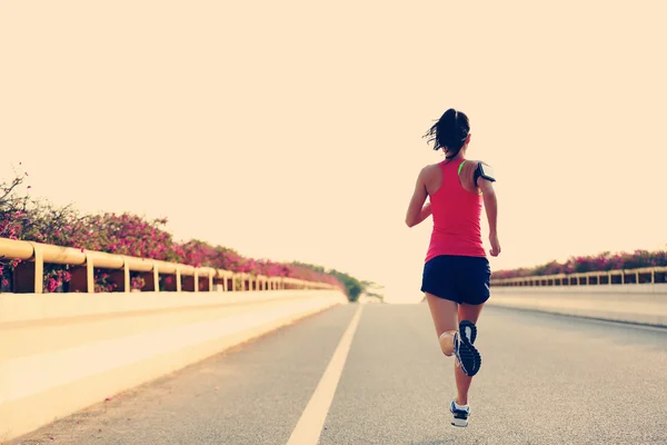 Žena běžec na silnici — Stock fotografie