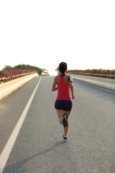 Женщина бегущая по дороге — стоковое фото