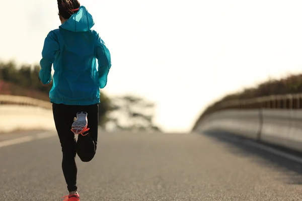 Fitness woman running on sunrise road — Stock Photo, Image