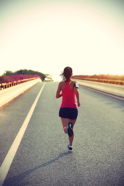 Kvinnan löpare körs på väg — Stockfoto