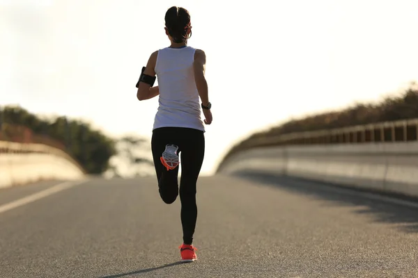 Фитнес-женщина бежит по дороге восхода солнца — стоковое фото