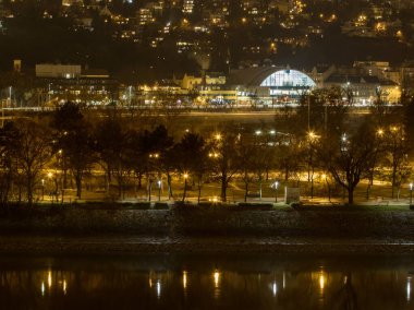 Gece yarısı şehirde nehir kıyısının ortasında bir panorama.