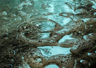 Turkuaz desenli ıslak cam yüzeyde bir sürü küçük kabarcık var.