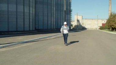 Tarım silolarını denetleyen planları olan profesyonel mühendis.