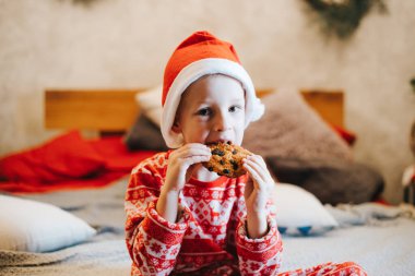 Tatlı çocuk evde lezzetli kurabiyeler yiyor.