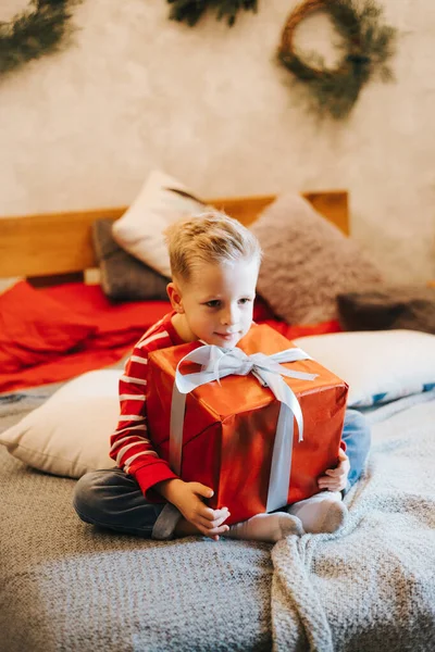 Noel hediyesini elinde tutan komik çocuk. Noel konsepti.