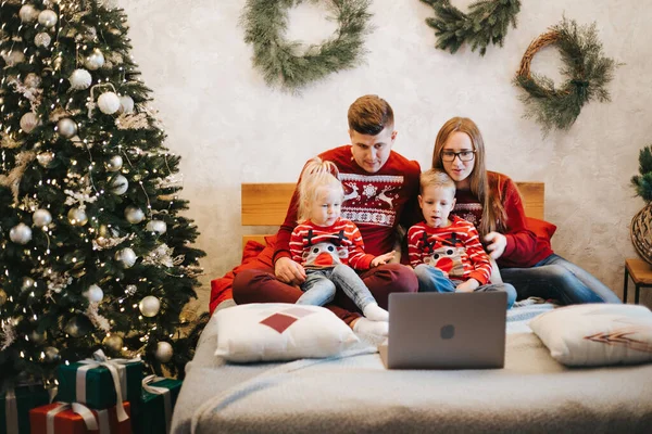 Glückliche Familie schaut an Weihnachten gemeinsam Film Stockbild