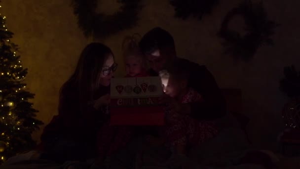 Heyecanlı aile, Noel gecesi hediye paketi açıyor. — Stok video