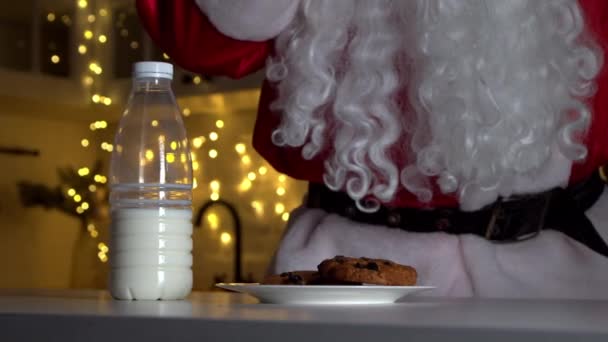 Santa Claus comiendo galletas y bebiendo leche en Navidad — Vídeo de stock