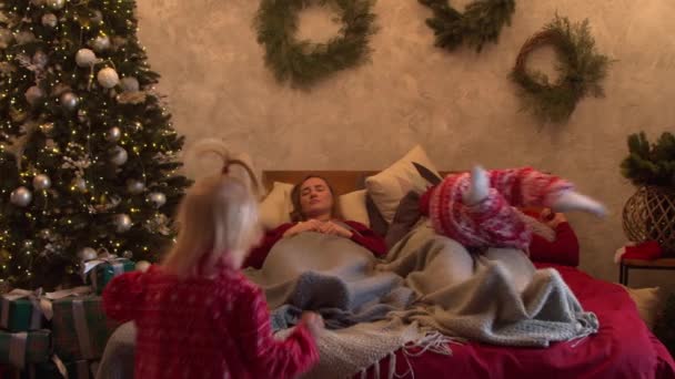 가족들은 크리스마스 아침 침대에서 즐겁게 놀고 껴안고 있다 — 비디오