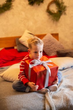 Noel hediyesini elinde tutan komik çocuk. Noel konsepti.