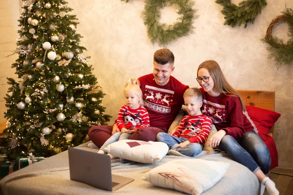 Glückliche Familie schaut an Weihnachten gemeinsam Film lizenzfreie Stockfotos