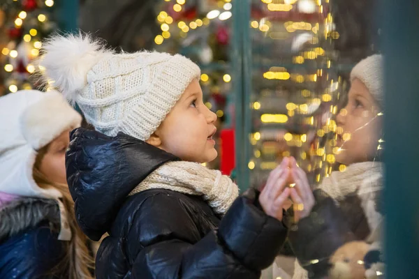 Happy kids examining toys in shop window together Stock Image