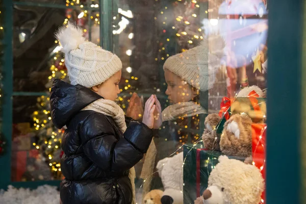 Neugieriges Kind begutachtet Spielzeug im Schaufenster Stockfoto