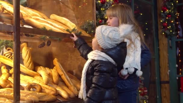 เด็ก ๆ เลือกขนมปังในร้านเบเกอรี่ในตอนเย็น — วีดีโอสต็อก